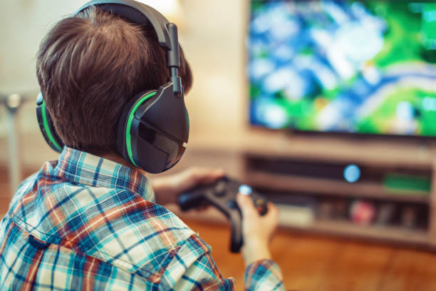 オンラインで大量のマルチプレイヤーゲームをプレイする若い子供 - addiction internet computer teenager ストックフォトと画像