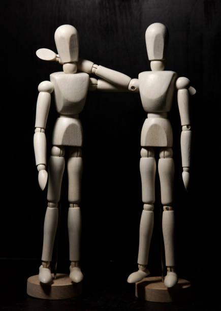istock Two drawing mannequins hugging one another on a black background 1207581978