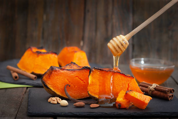 Peaces of baked butternut squash pumpkin with honey and nuts stock photo