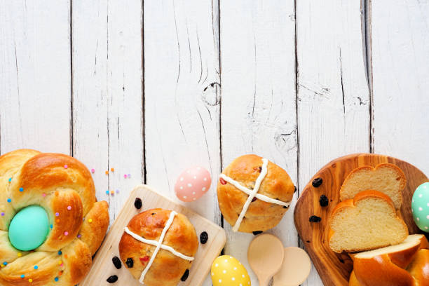 istock Easter assortment of fresh breads, overhead view bottom border with a white wood background 1207584470