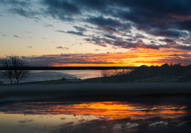 Cloudy sunset over Pegwell Bay, Kent with a foreground reflection in an open fan light window.