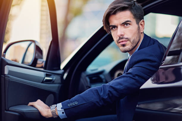 istock Businessman is entering/exiting his car 1207589756