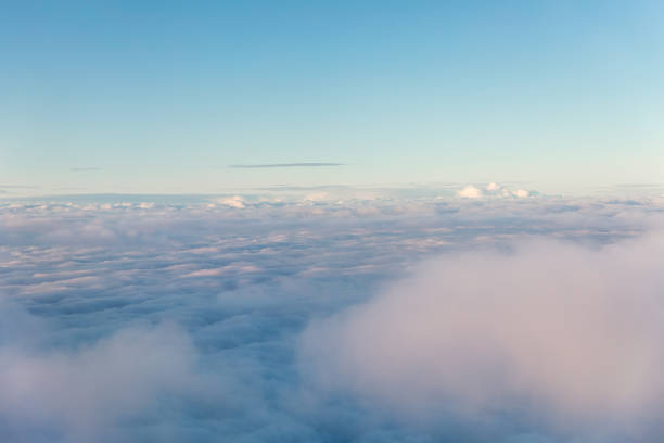 istock Aerial view of fluffy clouds through an airplane window 1207590893