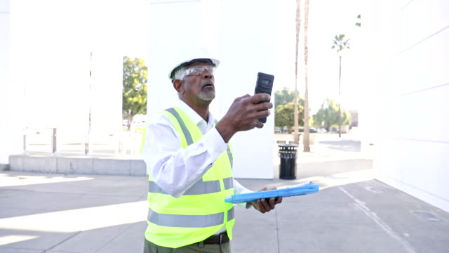 Senior Black Man Construction Manager Taking Pictures with Smartphone