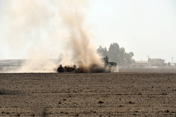 Brown dust flying from plow blades