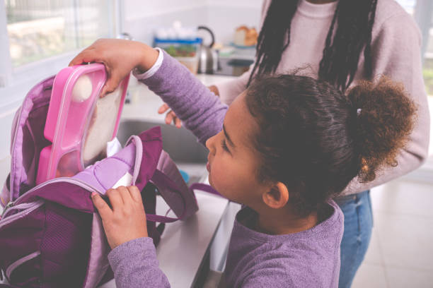 istock Girl packing lunch box for school. 1207598912