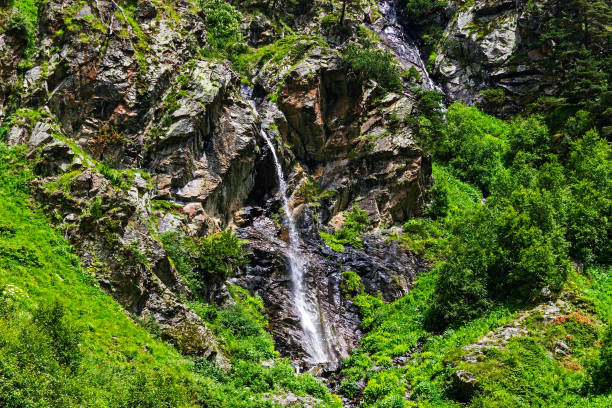 Barite waterfall flowing down a steep cliff in the Caucasus Mountains