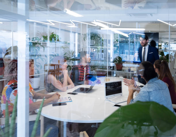 istock Presentation in business team meeting, seen from outside through windows 1207602228