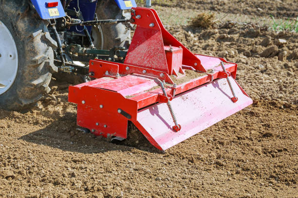 Farmer plowing the field. Tractor with a plow in a farm field.