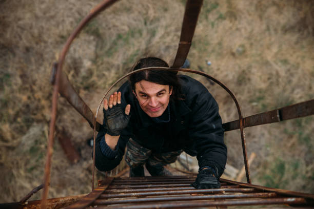 istock Man climbing rusty ladder to the roof 1207610963