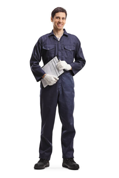 istock Young guy in a working uniform holding a clipboard 1207610967