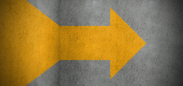 istock Yellow arrow painted on concrete walls 1207612418