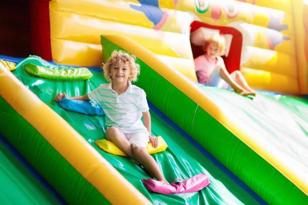 istock Child jumping on playground trampoline. Kids jump. 1207636695