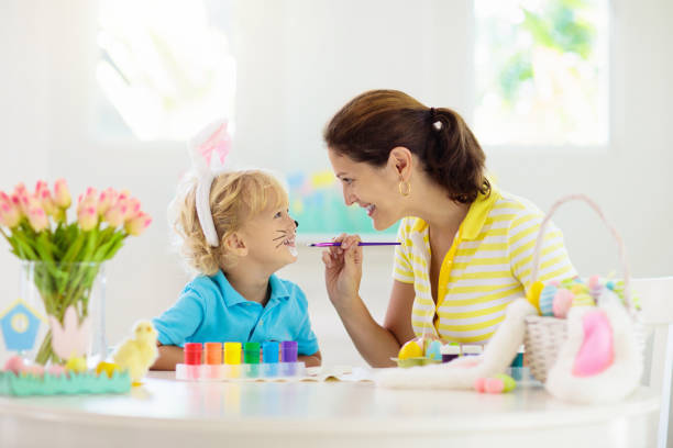 istock Mother and kids, family coloring Easter eggs. 1207639322