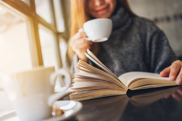 istock a beautiful woman reading a book while drinking coffee in the morning 1207643471