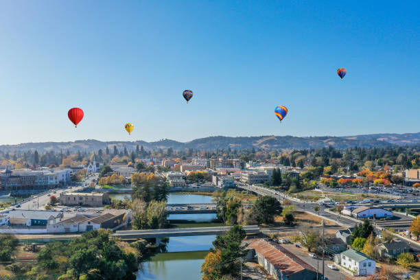 Aerial view of Downtown Napa with Hot Air Balloons An aerial view of downtown Napa with colorful hot air balloons drifting over the city against a blue sky. Downtown River with bridges. Colorful autumn colors fill the town. napa valley stock pictures, royalty-free photos & images