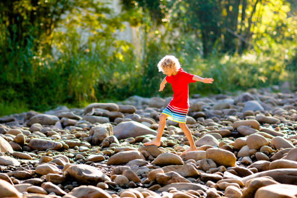 istock Child hiking in mountains. Kids at river shore. 1207651287