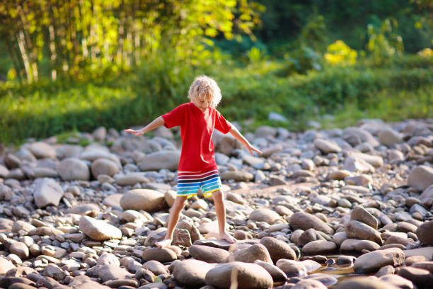 istock Child hiking in mountains. Kids at river shore. 1207651895