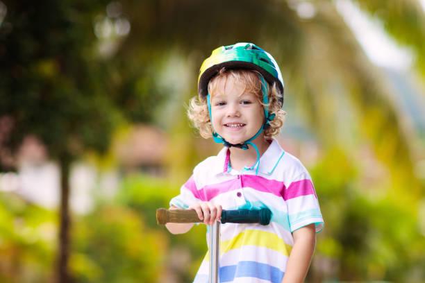 istock Little boy riding scooter. Kids ride kick board. 1207654295