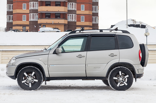 Novosibirsk, Russia - 02.18.2020: Side view of a Chevrolet Niva, a Russian-American car in the snow in winter