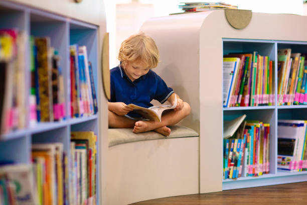 istock Child in school library. Kids reading books. 1207655506