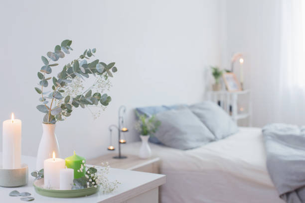 istock burning candles and eucalyptus in  vase in white bedroom 1207665401