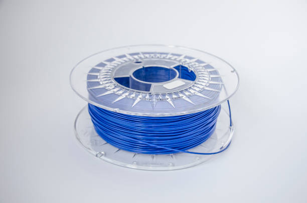 Coil of blue plastic for 3D printing Plastic for 3D printing. Blue plastic filament, red ABS/PLA coil for 3d printer on white background, isolated.  Plastic for three-dimensional object creation. Additive manufacturing 3d printing filament photos stock pictures, royalty-free photos & images