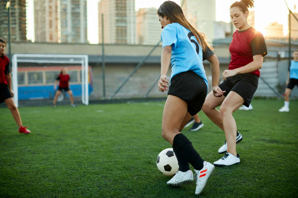 istock Female soccer player dribbling an opponent defender. 1207665681