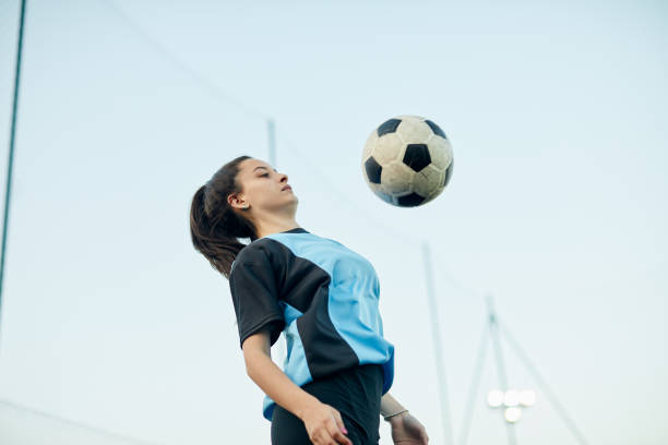 istock Soccer player controlling a ball with her chest in a training. 1207665713