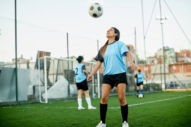 istock Soccer player controlling a ball with her chest in a training. 1207665720