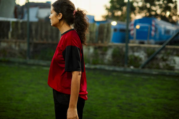 istock One female soccer player standing in the field. 1207665750