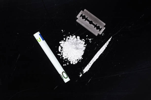 Portion of Cocaine on a dark plate (close-up) Portion of Cocaine on a dark plate as detailed close-up shot snorting stock pictures, royalty-free photos & images