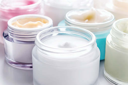 Close-up open jars of face creams.