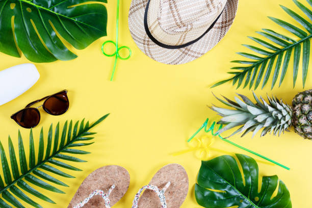 istock Colorful summer composition with straw hat, sunglasses, palm branche, pineapple and flip flops on yellow background top view. 1207677291