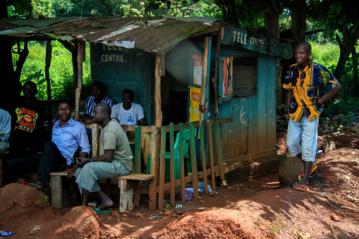 Conakry, Guinea - October 10th 2012: Group of man watching TV at a so-called tele centre, one of the very few locations where you find a TV in Conakry.