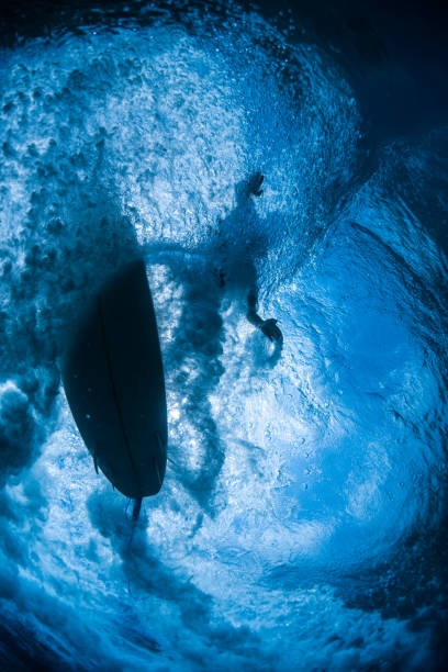 istock Underwater view of the surfer riding the wave 1207683859