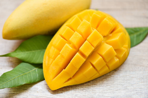 istock Mango slice and mango leaves from tree tropical summer fruit concept - Sweet ripe mangos cut half 1207684551