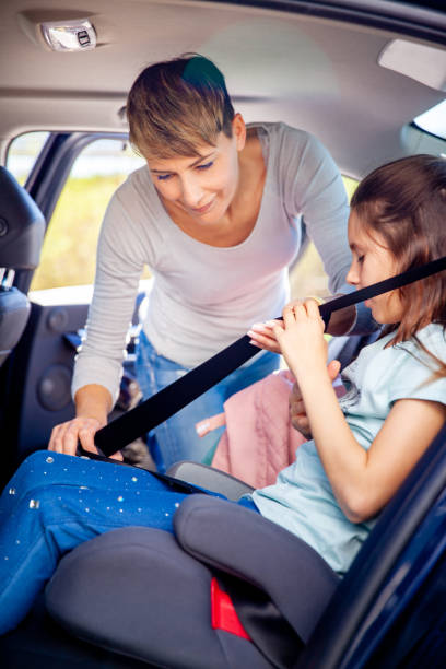 istock Mother Fastening Daughter's Seat Belt Before   Road Trip 1207685733
