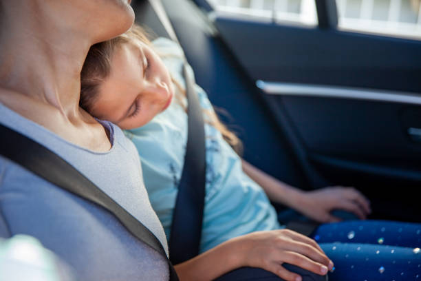 istock Daughter Leaning on Mother's Shoulder When Sleeping in Car 1207685744