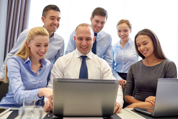istock smiling business people with laptop in office 1207687429