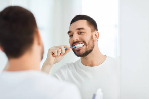 istock man with toothbrush cleaning teeth at bathroom 1207687755