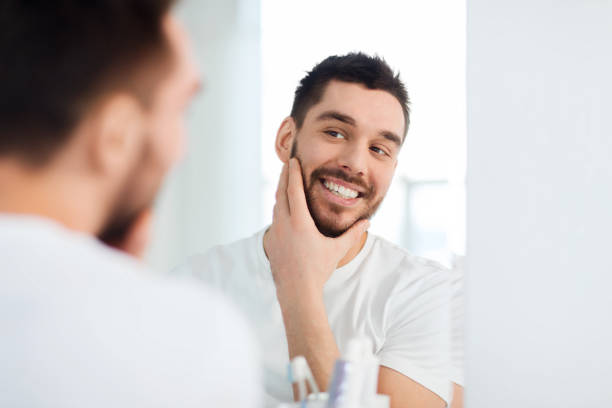 istock happy young man looking to mirror at home bathroom 1207687783