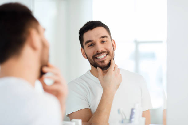 istock happy young man looking to mirror at home bathroom 1207687907