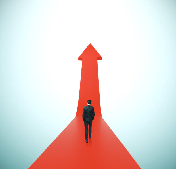istock Businessman walking on red arrow 1207691908