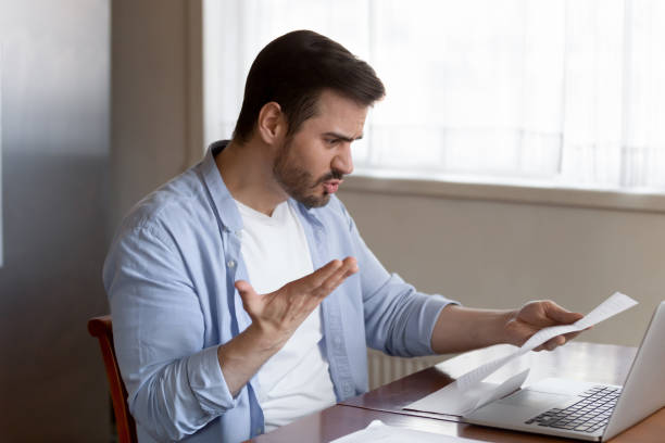 Frustrated man shocked by bad news in mail correspondence