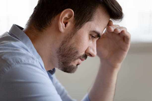 istock Unhappy young man lost in thought having troubles 1207691938