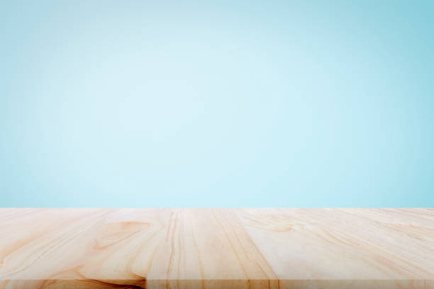 empty wooden deck table over light blue wallpaper background for present product. - color display imagens e fotografias de stock