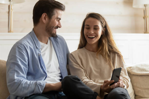 istock Happy young couple have fun using cellphone at home 1207696834