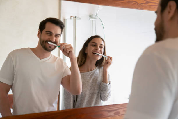 istock Smiling Caucasian young couple brush teeth together 1207696882