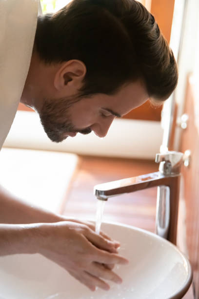 istock Caucasian man wash face do morning routine in bathroom 1207696885